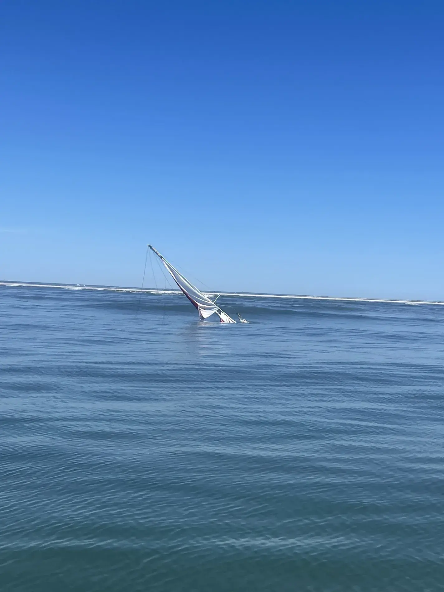Sailboat mast in calm coastal water after changing shore conditions